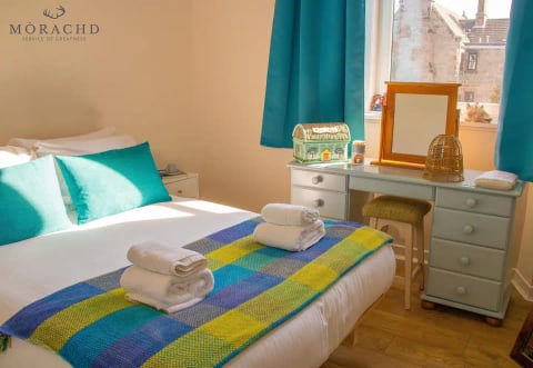 Bedroom with teal curtains and dressing table