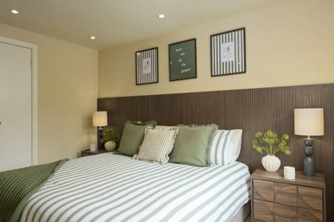 Double bed with green check cushions and table lamps