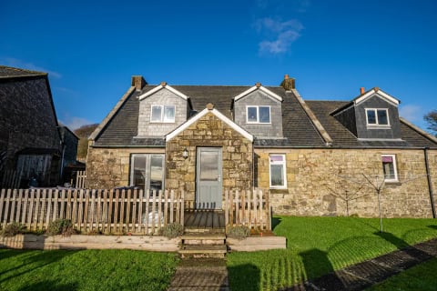 The cottage front with dormers and picket fence