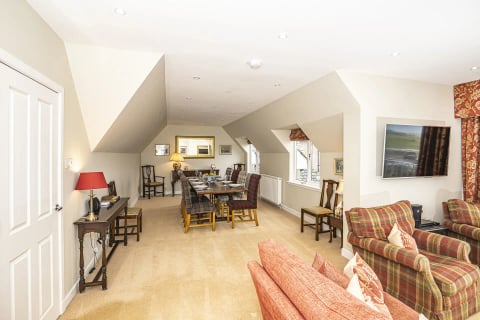 Attic living space with dining table and red sofas