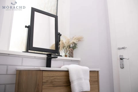 Bathroom vanity with swivel mirror and pampas grass