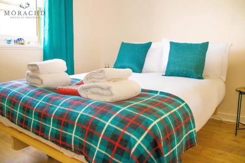Double bed dressed with a bold tartan throw