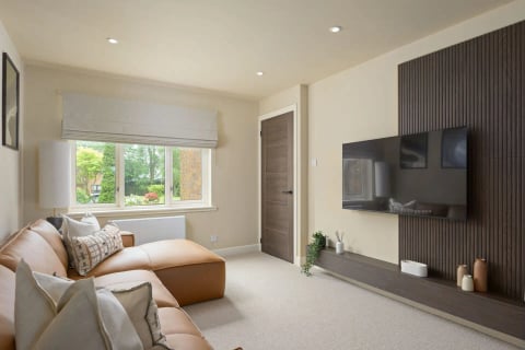Lounge with wall-mounted TV and tan sofa