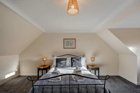 Double bed with plaid cushions under the pendant
