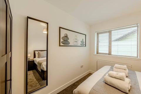 Bedroom with full-length mirror and window blinds