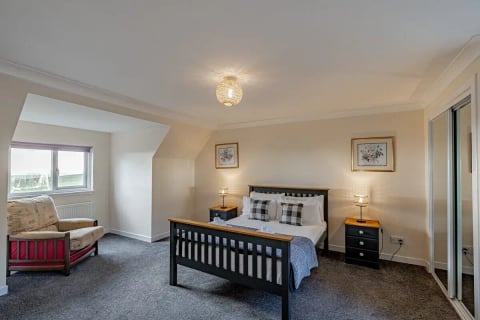 Double bed with grey throw in the eaves bedroom