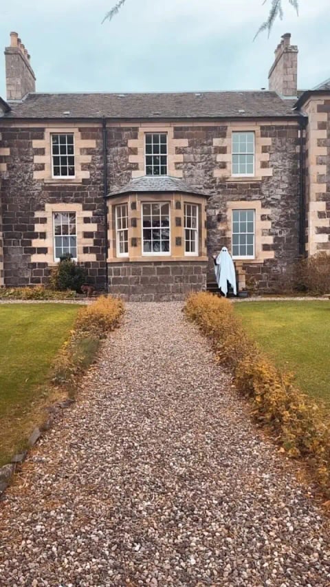 The stone front with bay window and gravel path
