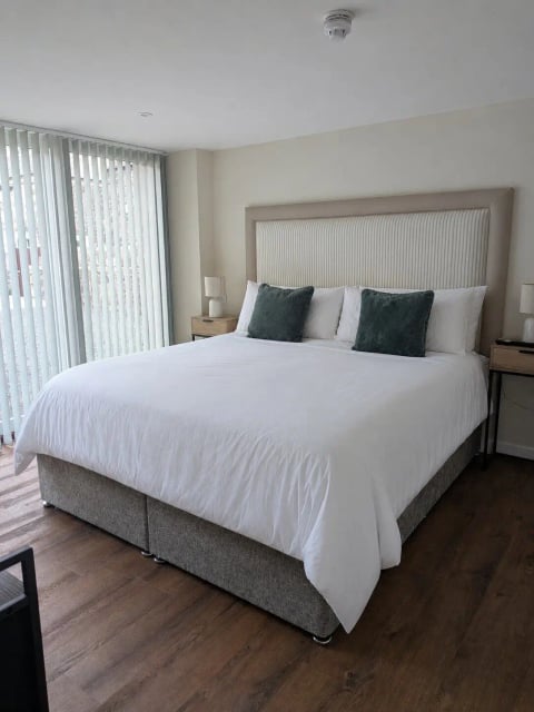 Super-king bed with green cushions and terrace doors