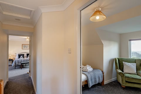 Upstairs landing into a bedroom with towels laid out