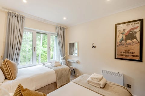 Twin beds with throws and towels laid out