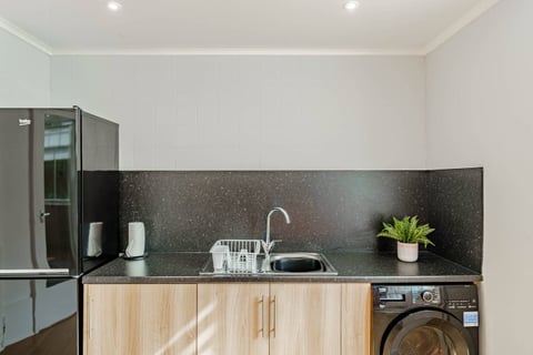 Kitchen sink beneath the dark splashback