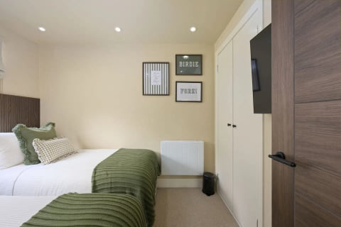 Single room with green throw and golf prints