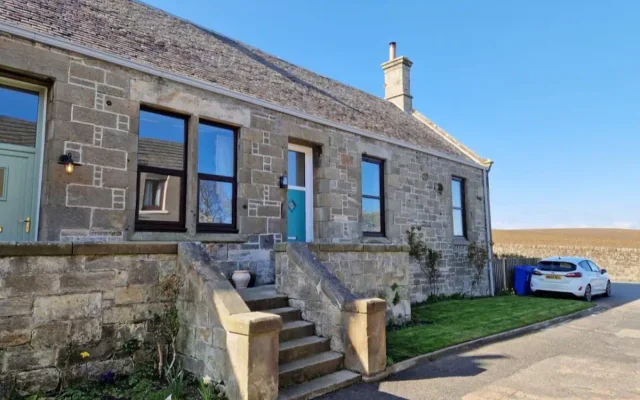 Linton, Kinghorn - stone cottage with steps up to the teal front door