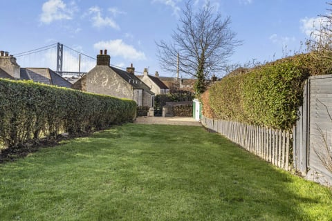 Long lawned garden with hedges and picket fence