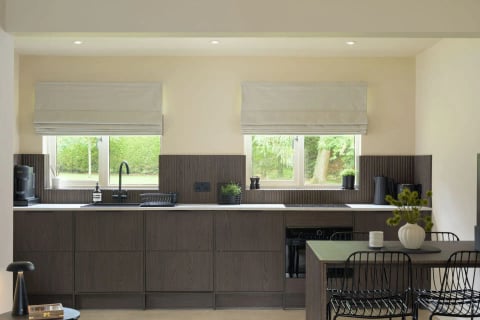Kitchen with black tapware and roman blinds