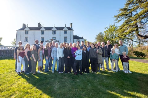 A large guest party gathered on the lawn outside a Mòrachd country house