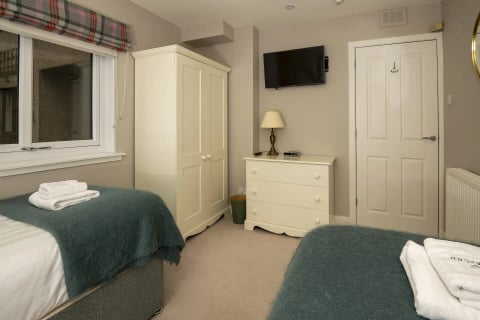 Twin room with TV and cream furniture