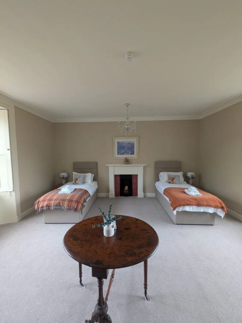Twin room with fireplace and tartan throws