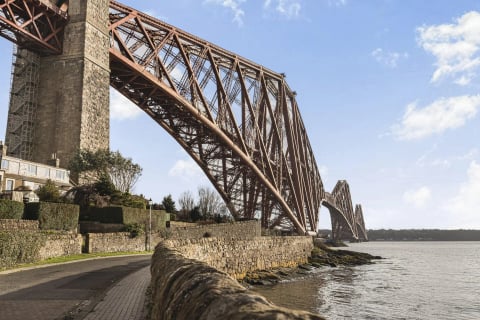 The Forth Rail Bridge arching over the village road