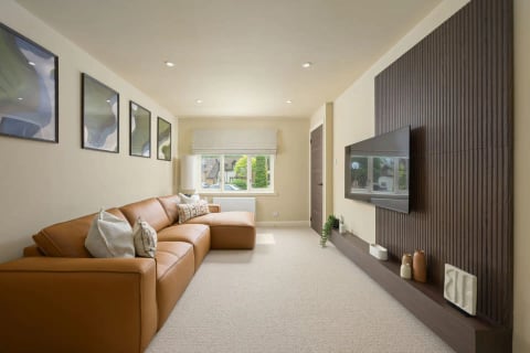 Long living room with leather sofa and prints