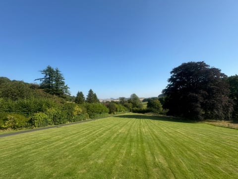 Freshly mown striped lawn with countryside views beyond