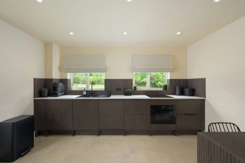 Dark-panelled kitchen with twin roman blinds