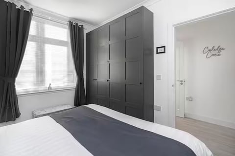 Double bedroom with charcoal wardrobes and grey bedding