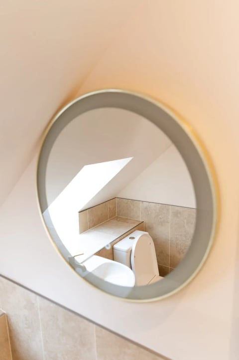 Porthole mirror reflecting the shower room