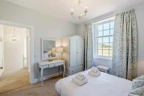 Bedroom with dressing table, mirror and fresh towels