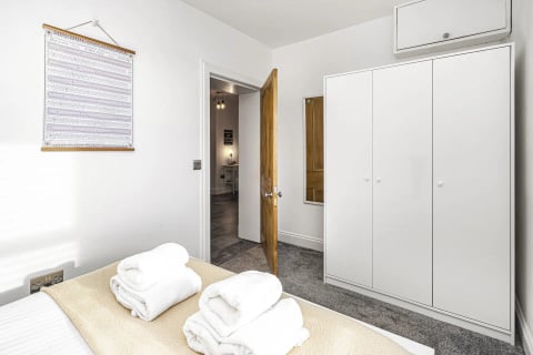 Fresh towels on the bed by the wardrobe