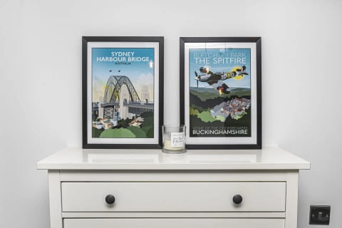 Travel prints and candle on the bedroom dresser