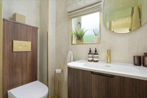 Bathroom basin with round mirror and toiletries