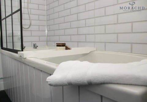 Bath with white metro tiles and towels laid over