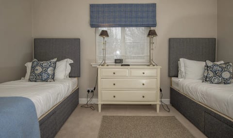 Twin bedroom with dresser and table lamps