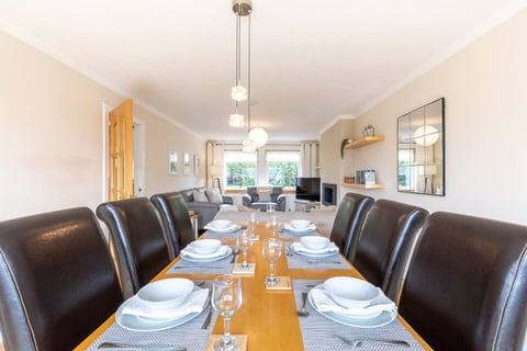 Dining room with long table set for eight beneath a pendant light