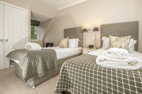 Twin bedroom with wool throws and bedside lamps