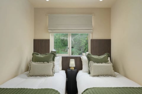 Twin beds with ruffled green gingham cushions