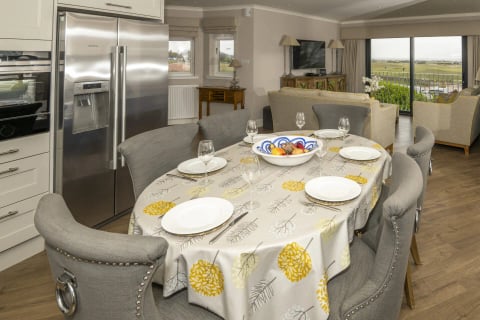 Oval dining table dressed for dinner beside the kitchen