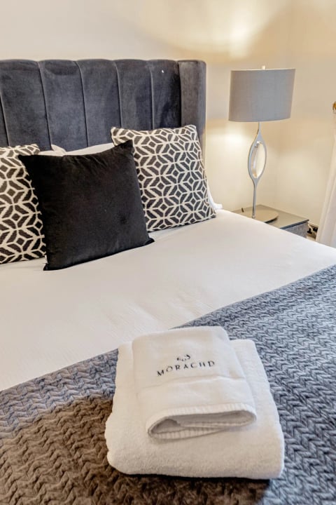 King bed with monochrome cushions and Mòrachd towels