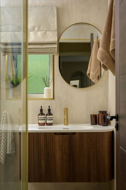 Bathroom vanity with round mirror and walnut drawers