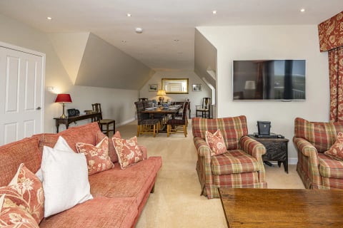 Lounge with salmon sofas and TV in the eaves