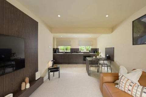Studio living space with kitchen, desk and leather sofa
