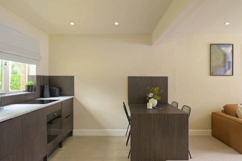 Compact kitchenette with dark cabinetry and desk
