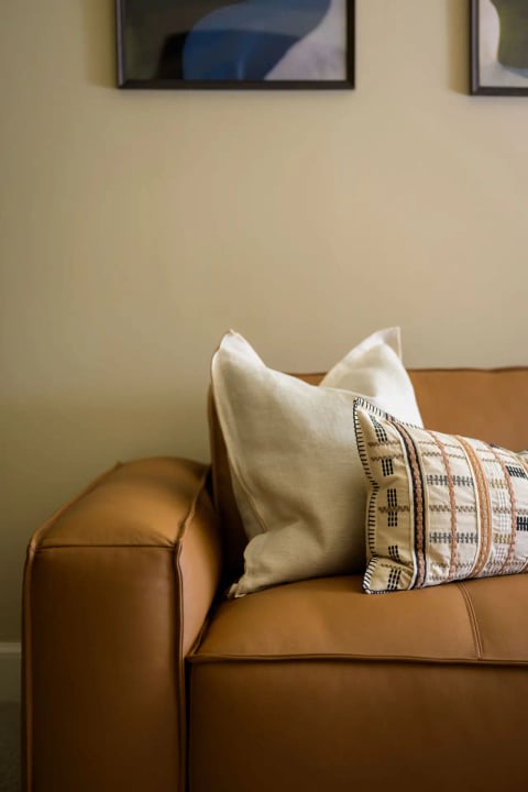 Cushion detail on the tan leather sofa