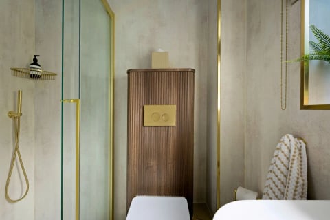 Shower room with gold-framed enclosure and walnut column