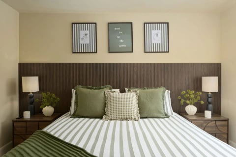 King bed with striped linen and framed prints