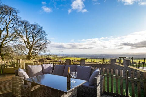 Outdoor dining set with wine on the deck at dusk