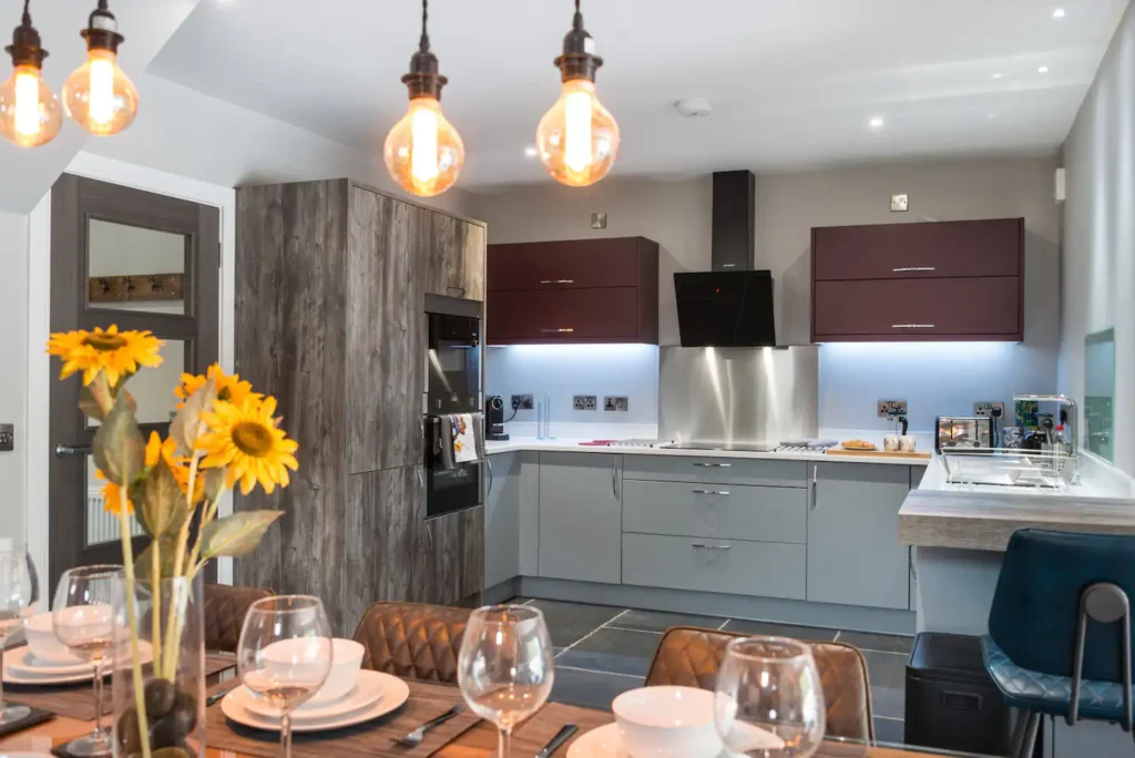 Modern kitchen and dining area with sunflowers, stylish lighting, and sleek cabinets.