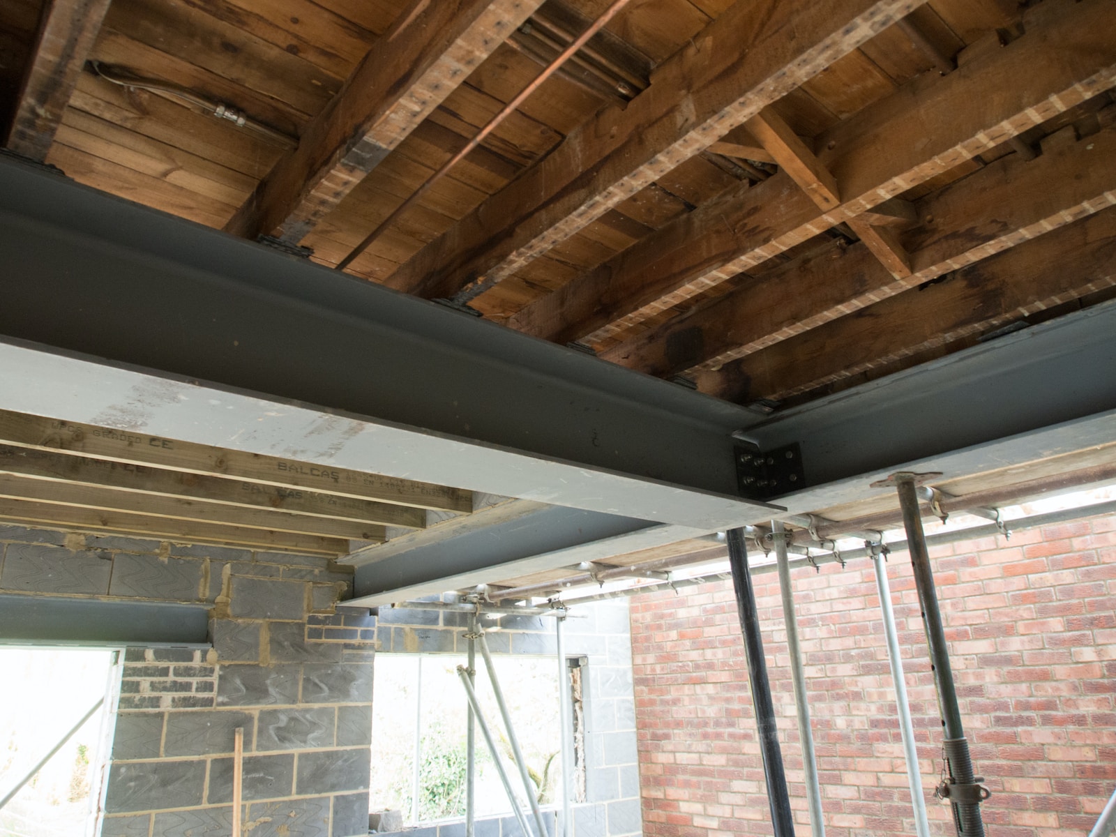 Steel beams and wooden rafters in a constructing building's interior offer structural support.