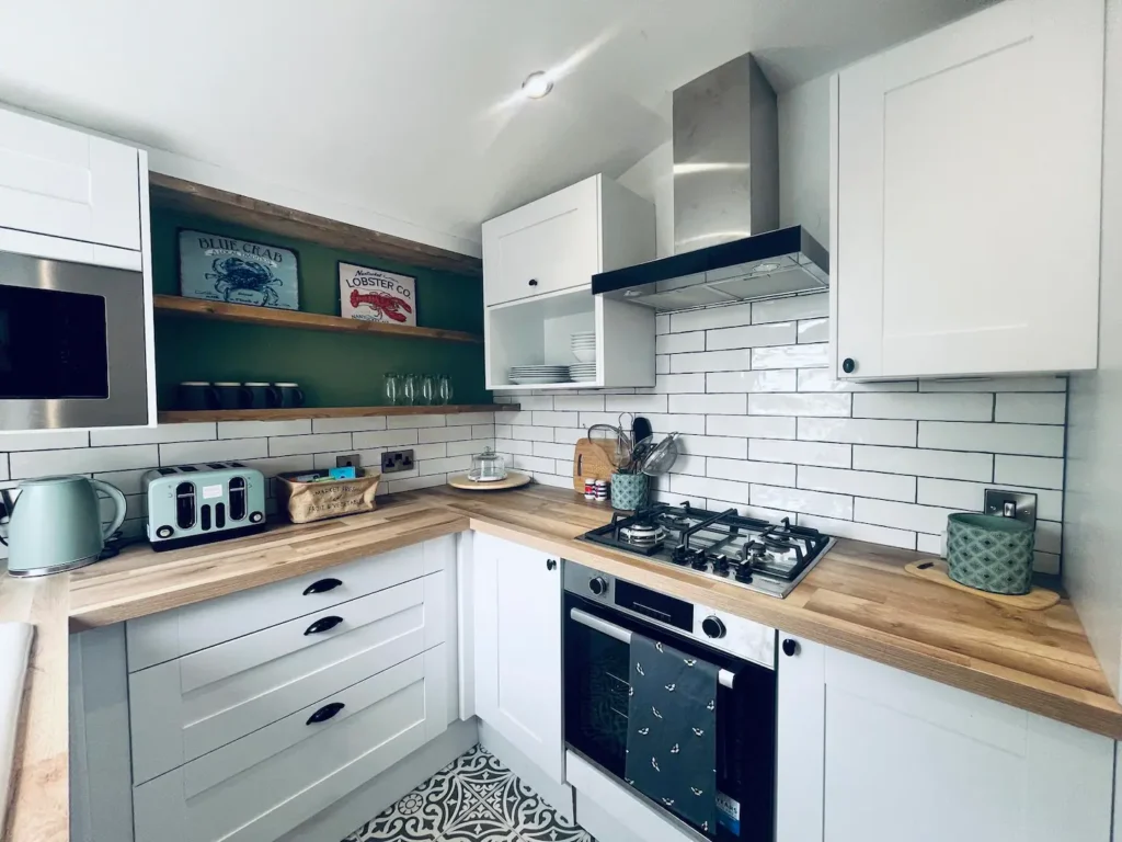 Modern kitchen with white cabinets, wooden countertops, and stainless steel appliances for a sleek, cozy look.